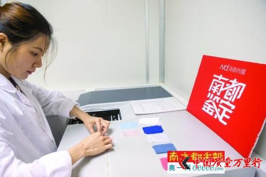 實驗員將防曬服的布料樣品放入紫外可見分光光度計進行檢測。