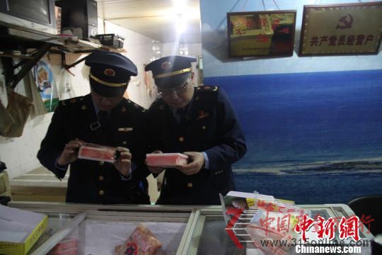 執(zhí)法人員檢查水產(chǎn)店冰柜。 韓璐 攝 執(zhí)法人員檢查水產(chǎn)店冰柜。 韓璐 攝