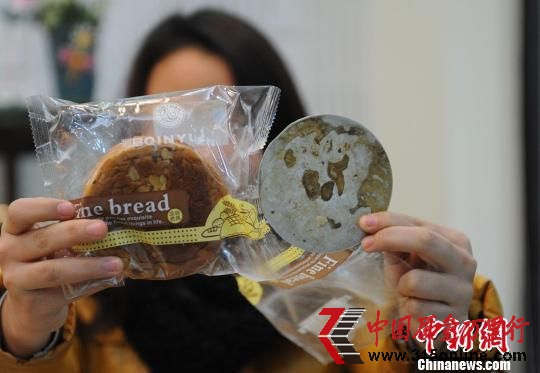 重慶市民向小姐一手拿著“紅豆密斯面包”,一手拿著從該品種面包中吃出的“鐵片”。