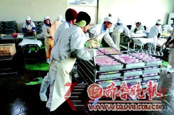 工人向外搬運生產加工好的“混裝羊肉”。