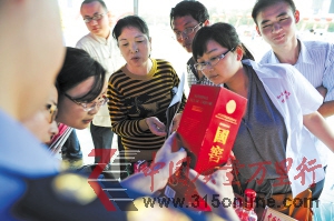 近日,工商執法人員正在向市民介紹真假國窖1573的辨別方法。賀文兵 攝 近日,工商執法人員正在向市民介紹真假國窖1573的辨別方法。賀文兵 攝